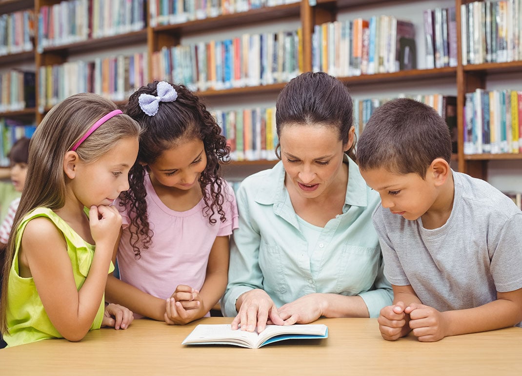 students-reading-book-with-teacher